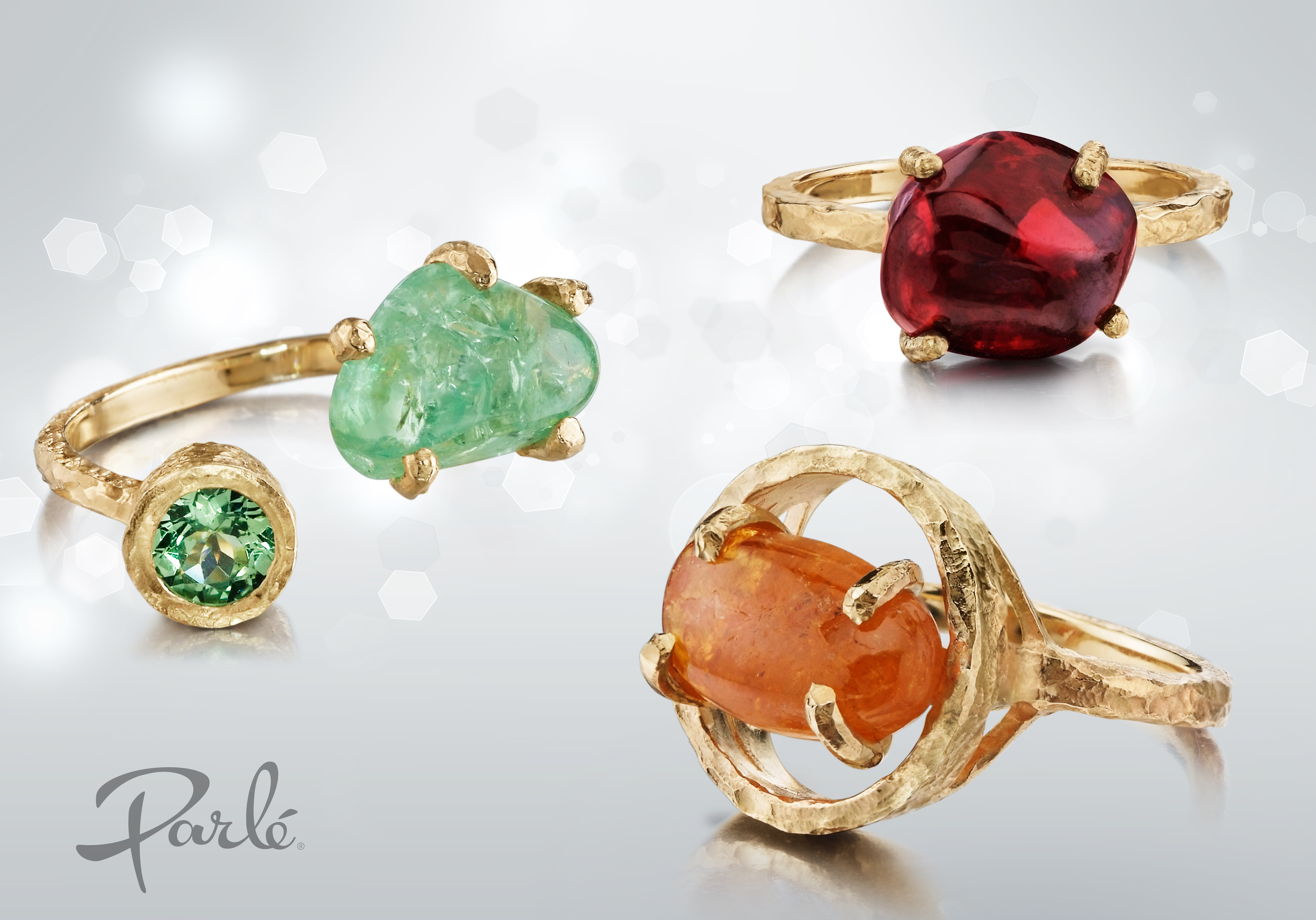 Three gold rings set with rough uncut gemstones in green, red and orange, with matching earrings