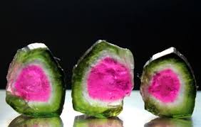Three watermelon tourmaline slices, each with a pink core inside a green rim