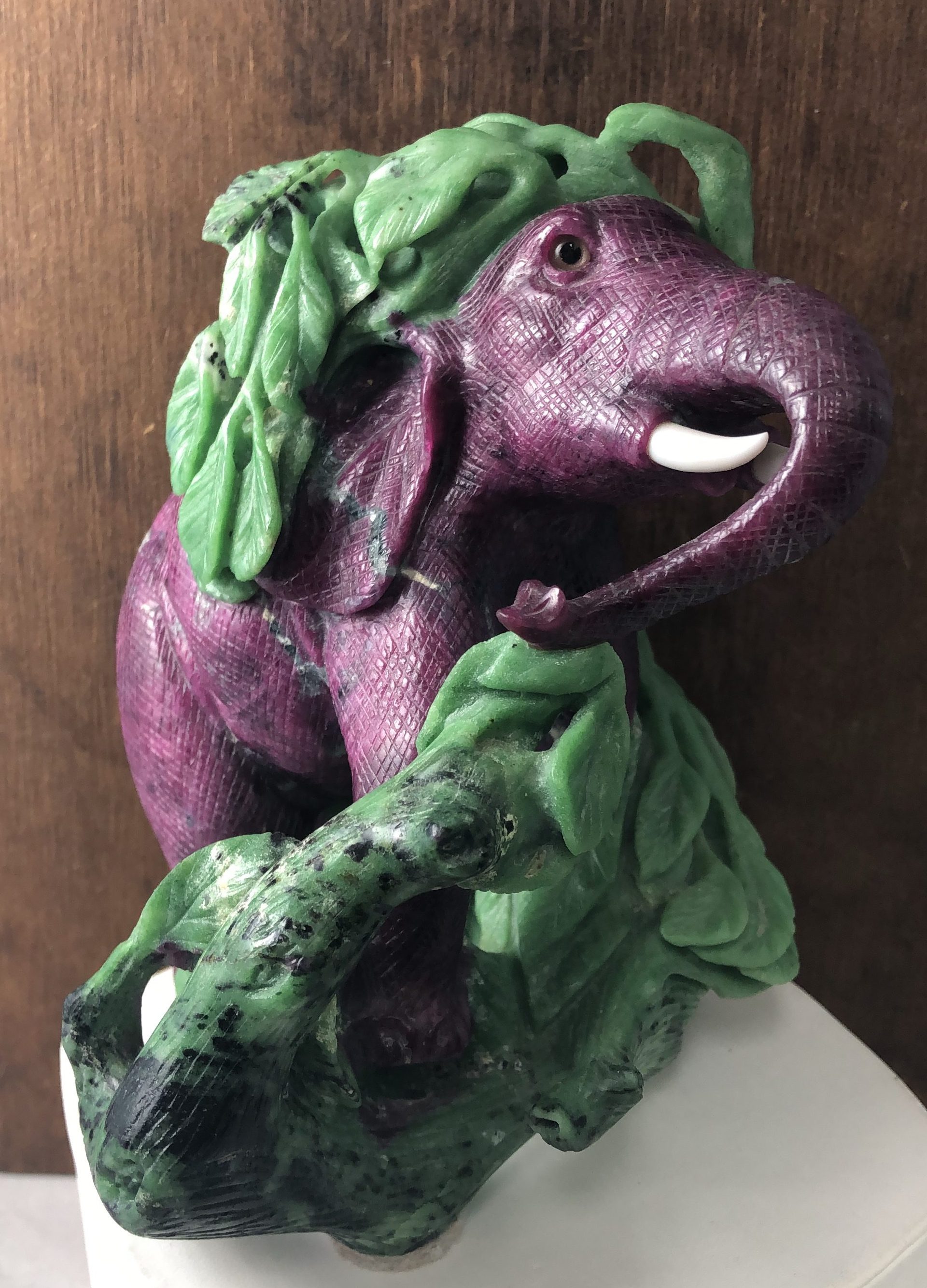 A carved figure of an elephant in ruby-in-zoisite, the pink ruby forming the body against green zoisite