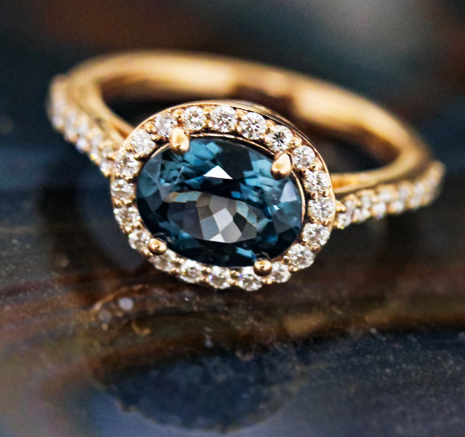 Oval grey-blue spinel ring with a diamond halo in rose gold