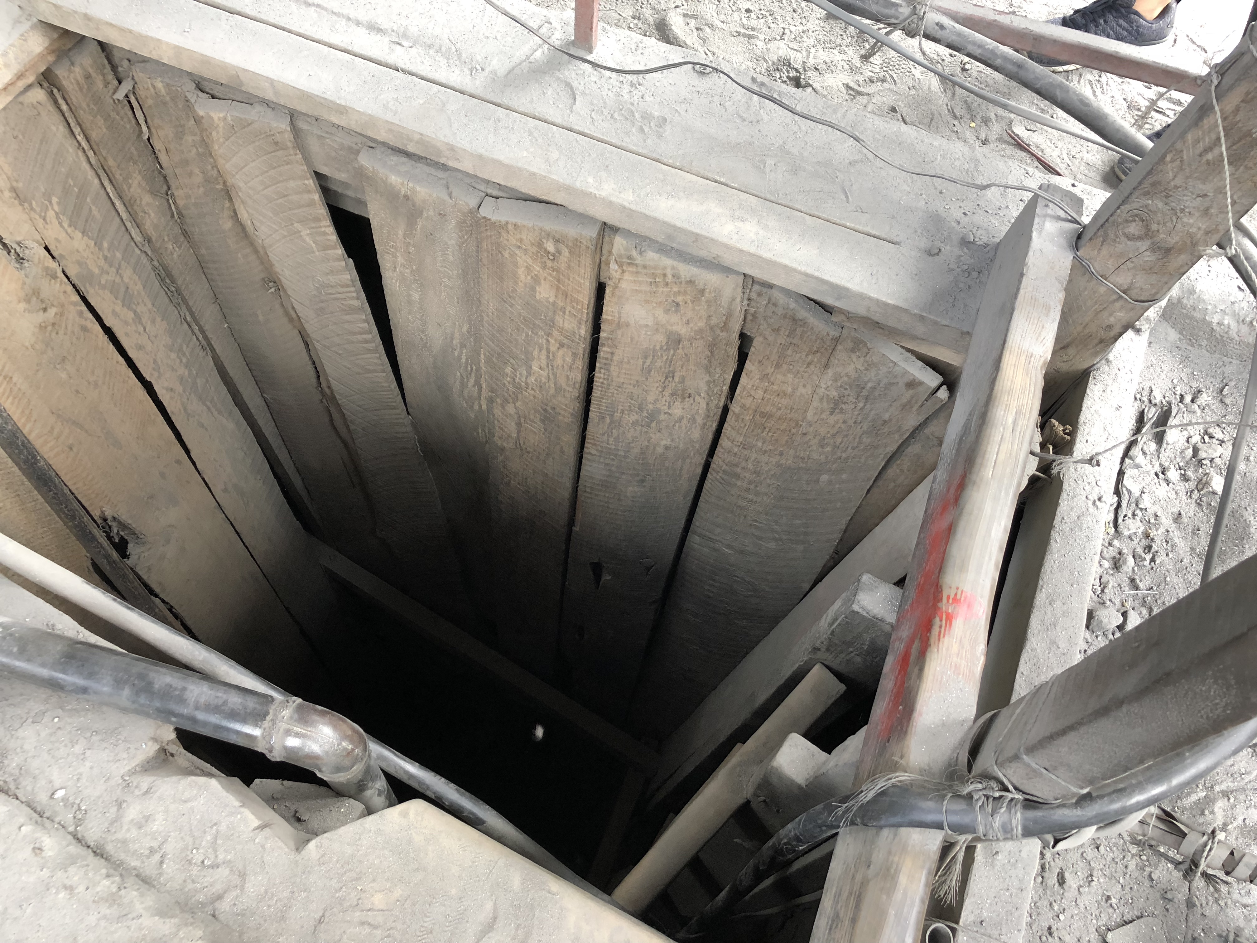 Looking down a narrow timber-lined mine shaft
