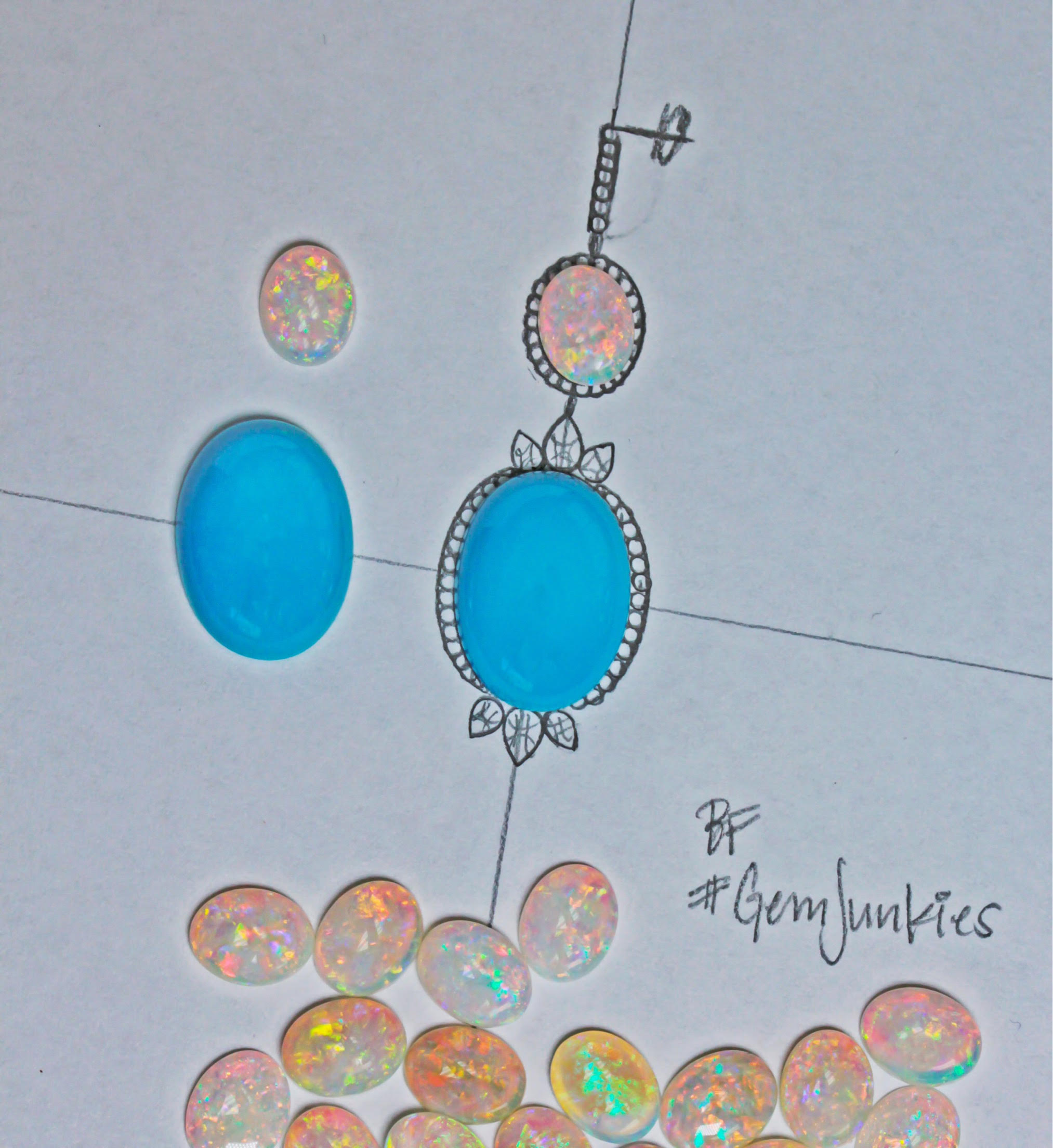 A jewellery design sketch of a pendant and earrings, laid out with the loose turquoise and opal cabochons that will be set into them